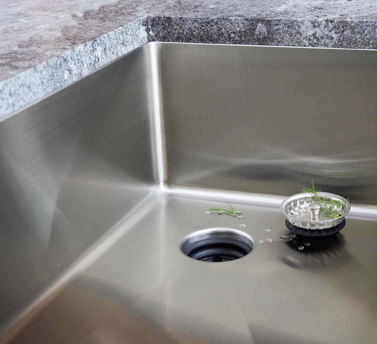 Detailed view of the 28-inch undermount stainless steel kitchen sink’s offset drain and smooth interior, showcasing its premium 16-gauge build.