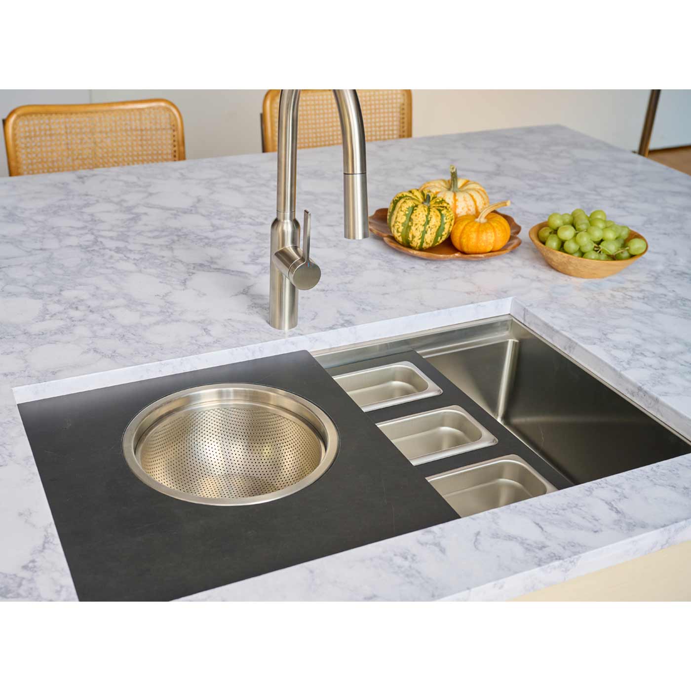 31-inch workstation kitchen sink with integrated accessories, including a colander and storage trays, enhancing functionality in a modern kitchen.