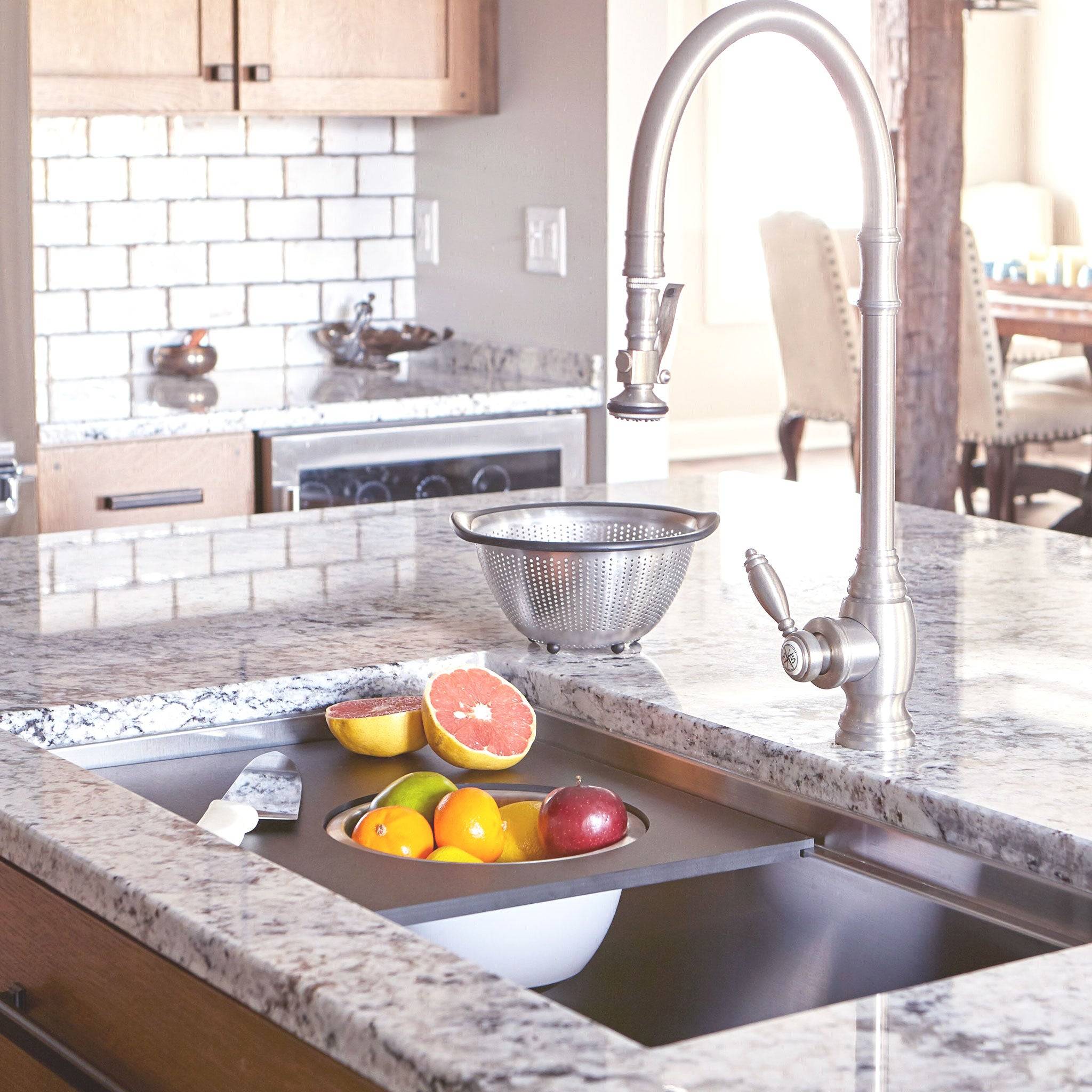18-inch black cutting board with stainless steel colander and mixing bowl, integrated into a workstation sink for efficient kitchen use.