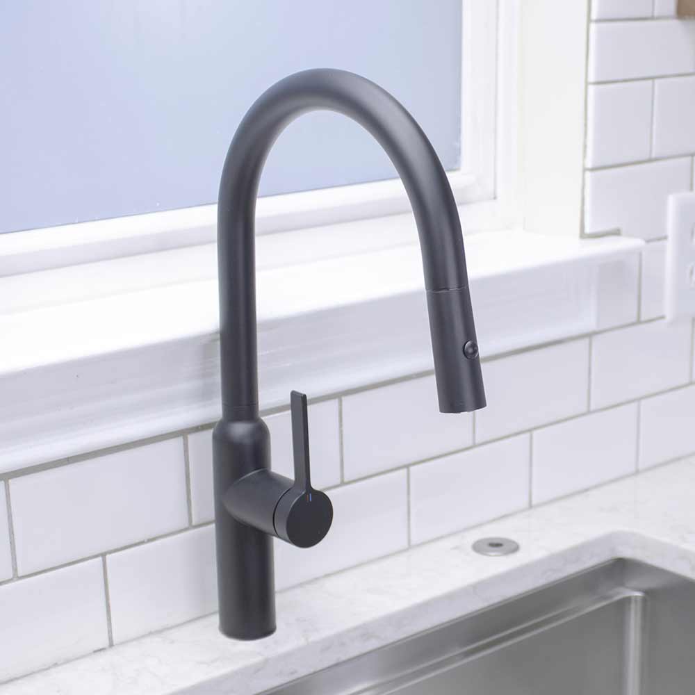 Matte black stainless steel Claudette Kitchen Faucet streaming water into Workstation Sink
