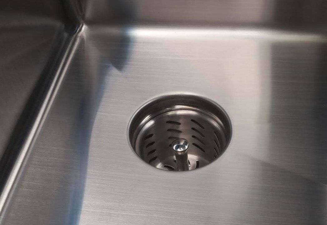 Close-up of Seamless Composting Deep Drain Kit installed in a stainless steel sink, featuring a deep strainer basket for efficient waste separation.