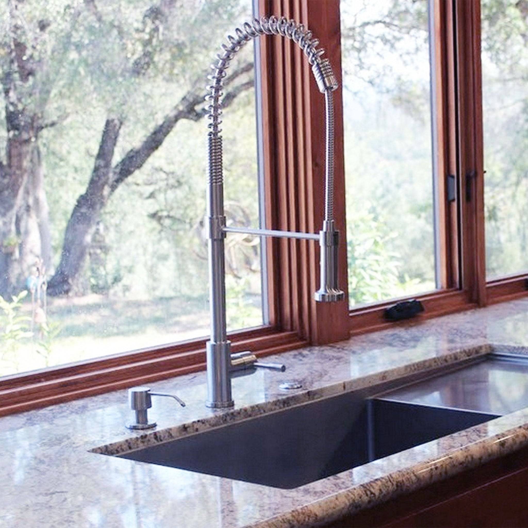 Jerry kitchen sink faucet in stainless steel with a high-arc spring design, installed on a granite countertop with a scenic outdoor view.