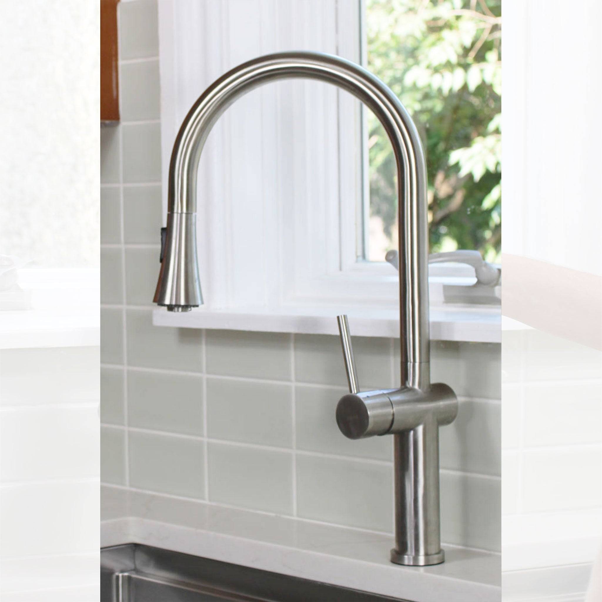 Bella stainless steel kitchen sink faucet with a high-arc design and brushed finish, installed in a modern kitchen with a tiled backsplash.