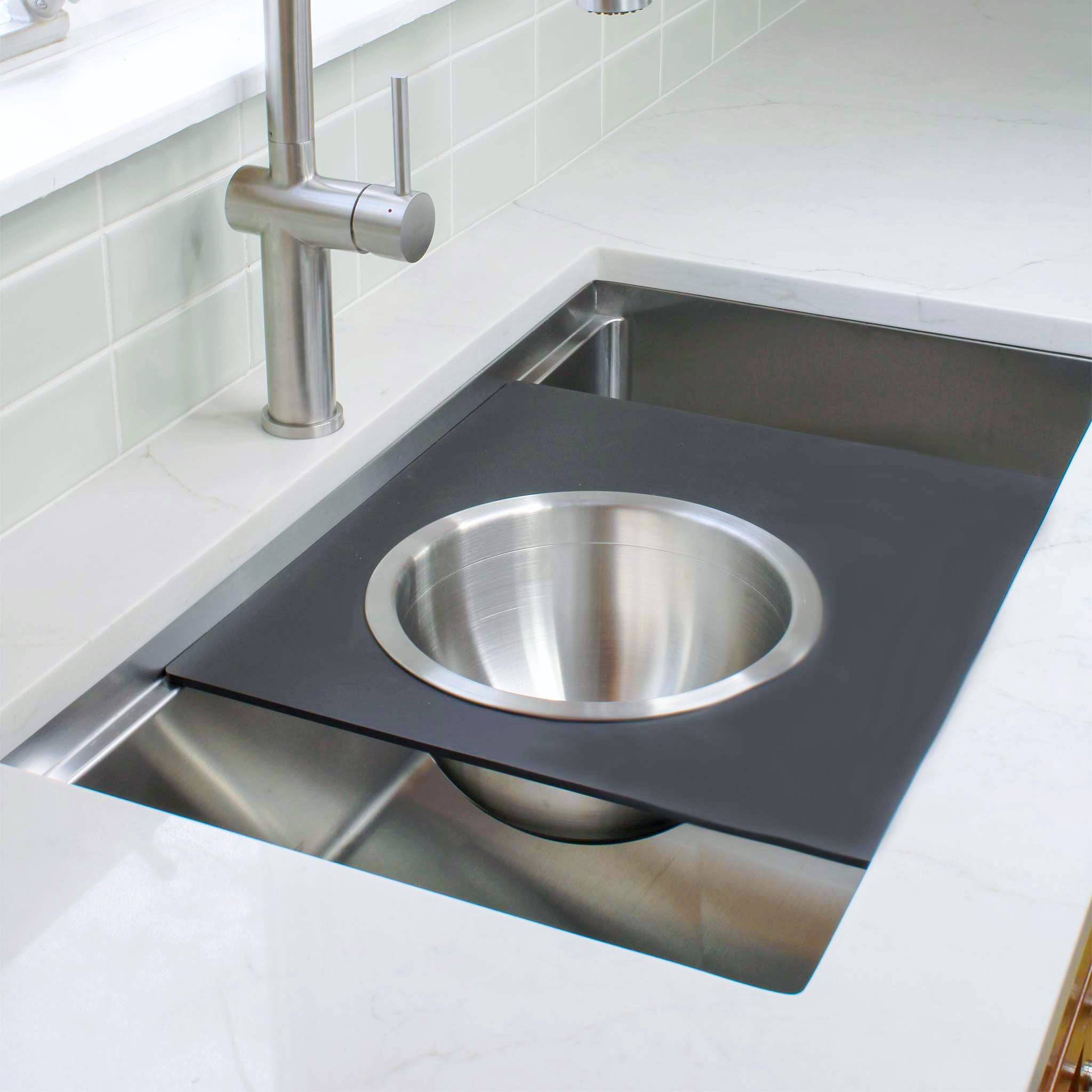 18-inch black cutting board with stainless steel mixing bowl, fitting securely over a workstation sink. Perfect for meal prep and mixing.