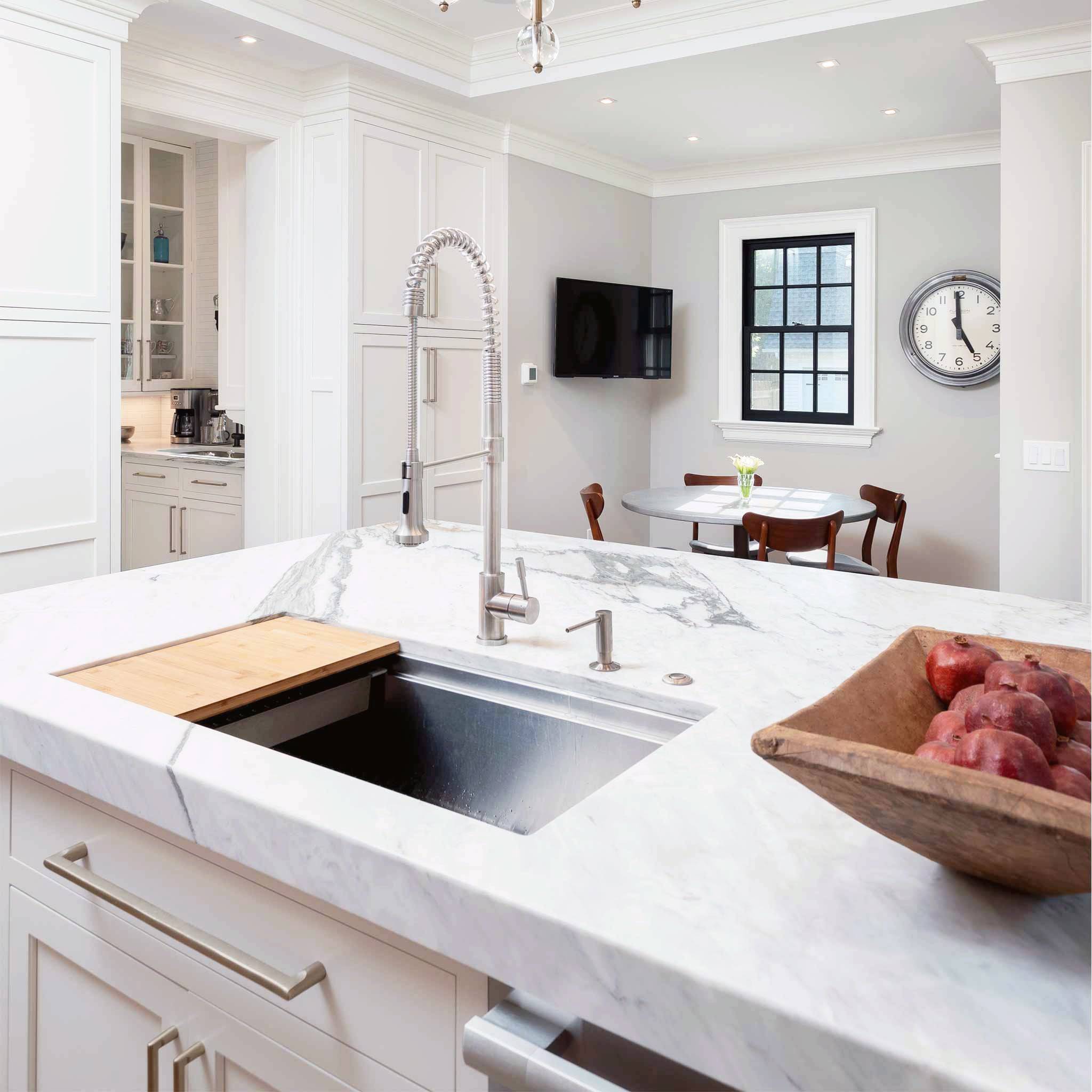 Modern kitchen featuring the Jerry stainless steel kitchen sink faucet with a high-arc spring spout, installed on a marble island countertop.