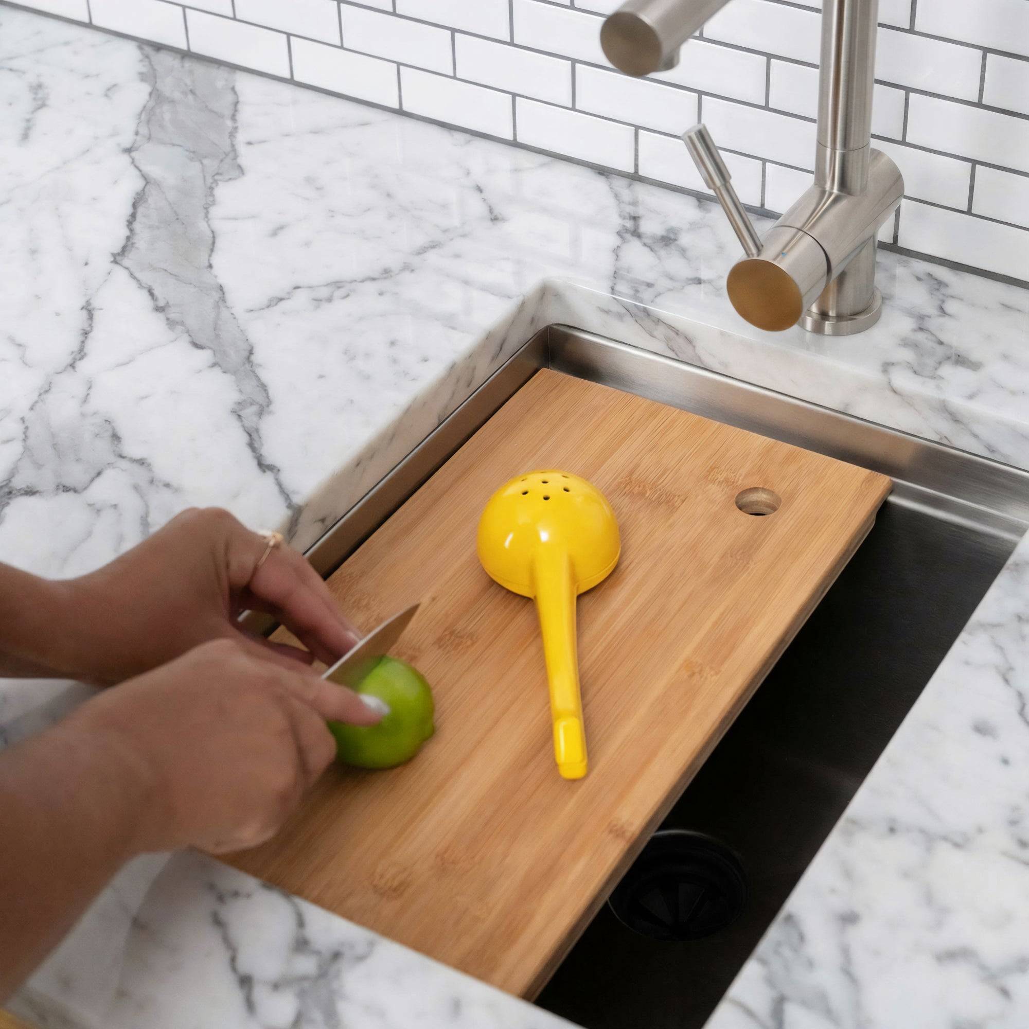 15-inch stainless steel workstation bar sink with a wooden cutting board in use. Ideal for food prep in compact kitchen spaces.