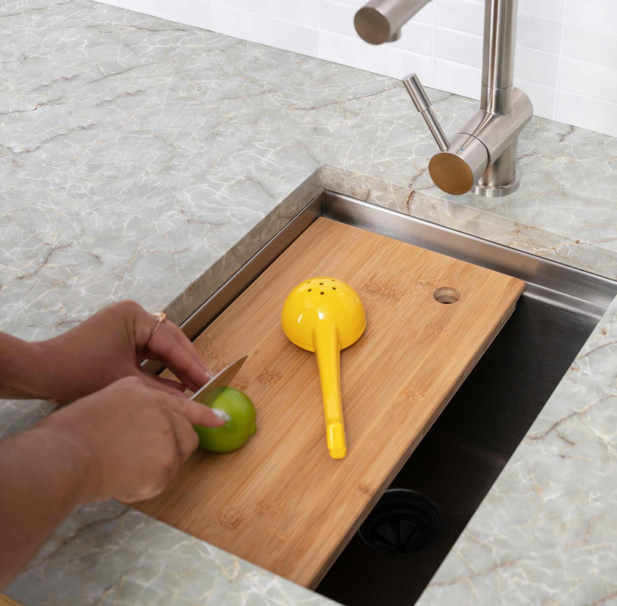 15-inch stainless steel workstation bar sink with a wooden cutting board in use. Ideal for food prep in compact kitchen spaces.