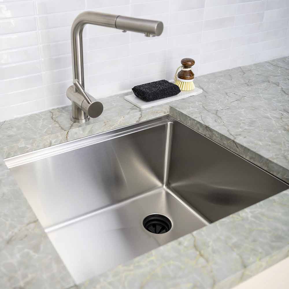 Modern kitchen with a 22-inch stainless steel undermount workstation sink. Features an offset drain and sleek, seamless design.