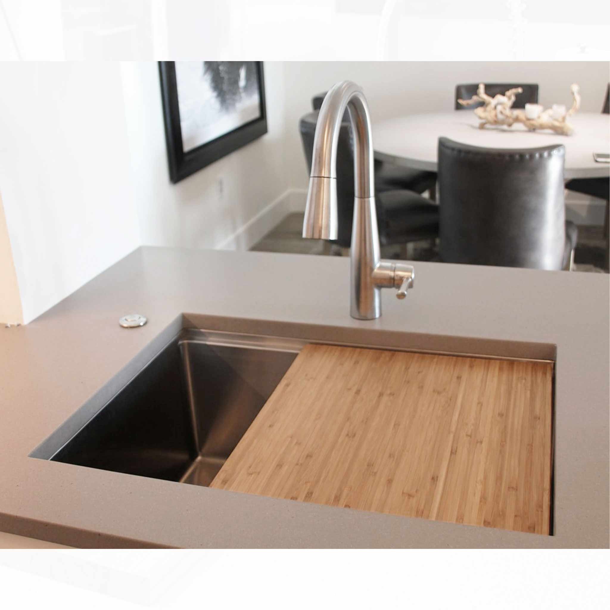 Customer photo of our 26" workstation sink with offset drain left and bamboo cutting board sink accessory. Made with 16 gauge type 304 stainless steel and designed for undermount installation. Features Create Good Sinks' patented, award-winning seamless drain