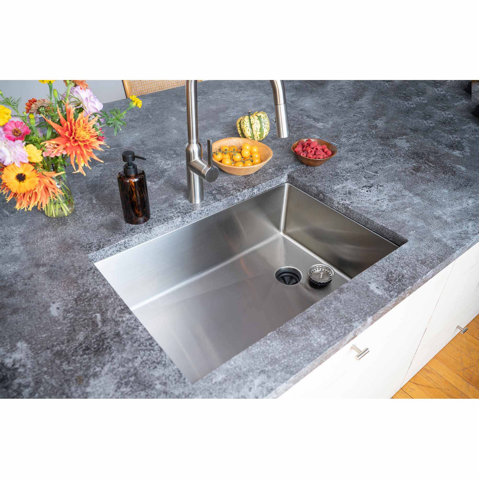 Top view of a 28-inch undermount stainless steel kitchen sink with a single bowl and offset drain, integrated into a stylish countertop.
