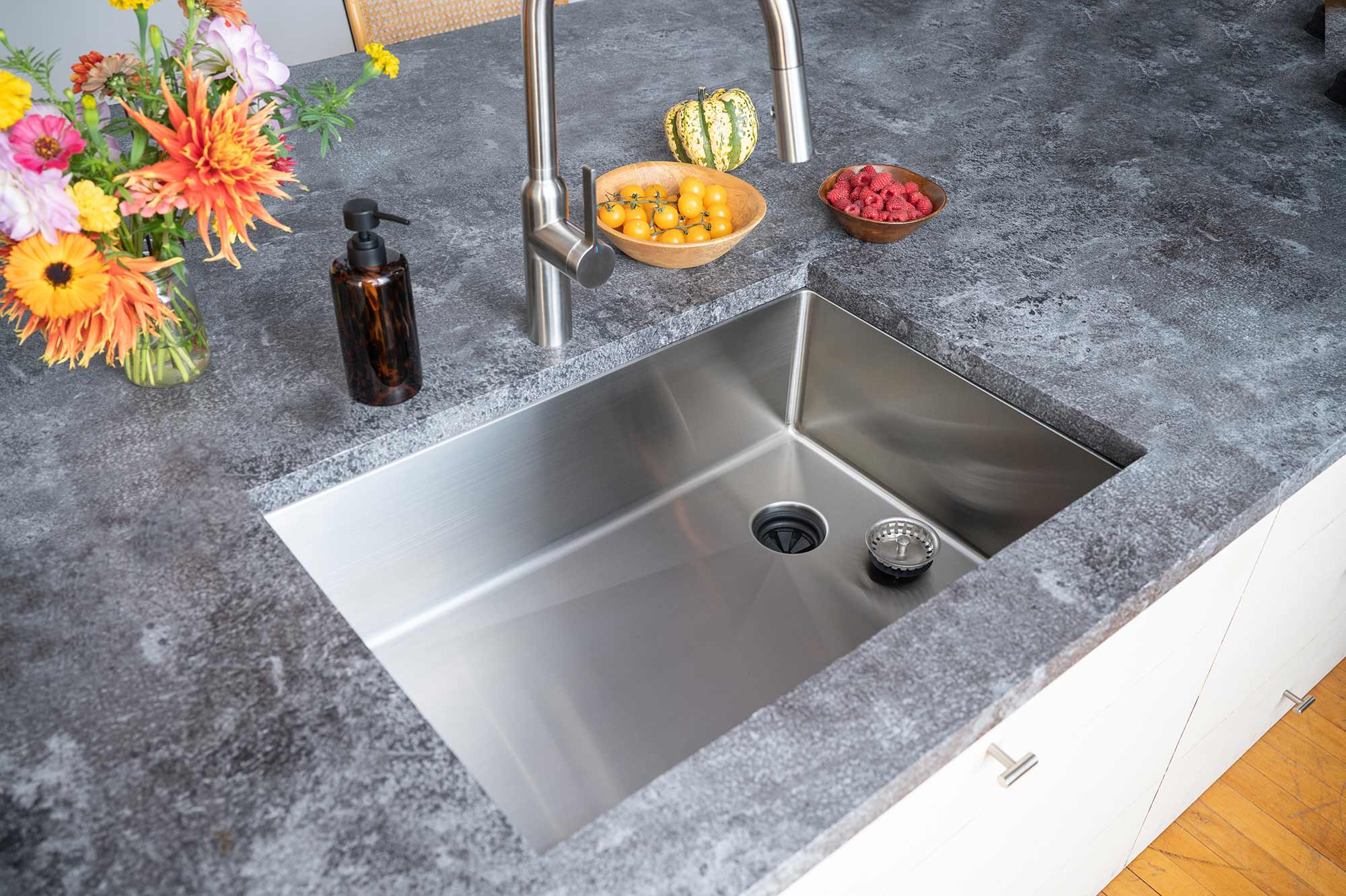 Modern kitchen with 28-inch stainless steel undermount sink, featuring an offset right drain and sleek design for a contemporary cooking space.