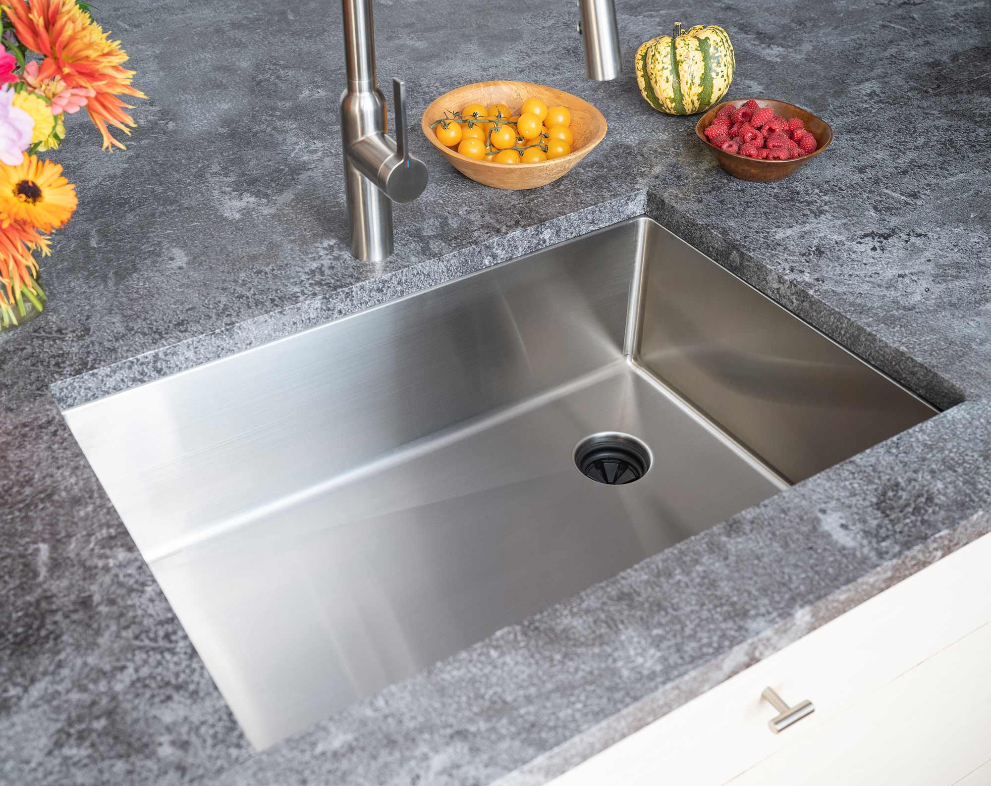 28-inch stainless steel undermount kitchen sink installed in a modern countertop, featuring an offset right drain and sleek single bowl design.