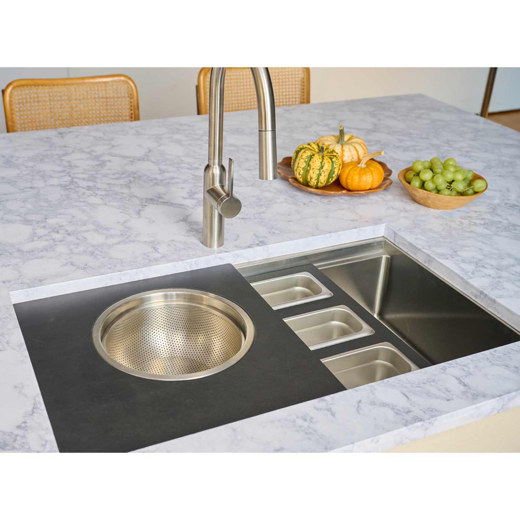 31-inch workstation kitchen sink with integrated accessories, including a colander and storage trays, enhancing functionality in a modern kitchen.