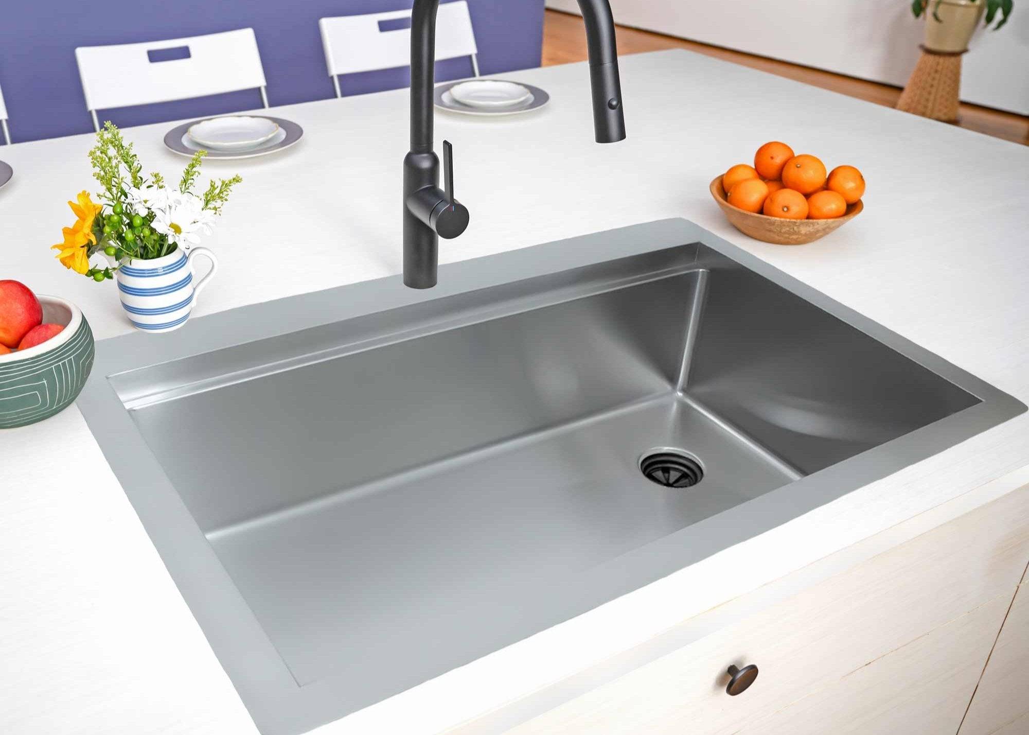 33 inch drop in top mount single bowl workstation sink made with 16 gauge stainless steel with offset drain to the right side installed in kitchen island with matte black faucet