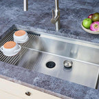Installed 33-inch stainless steel workstation sink with roll-up drying rack. Single bowl undermount design enhances kitchen functionality and style.