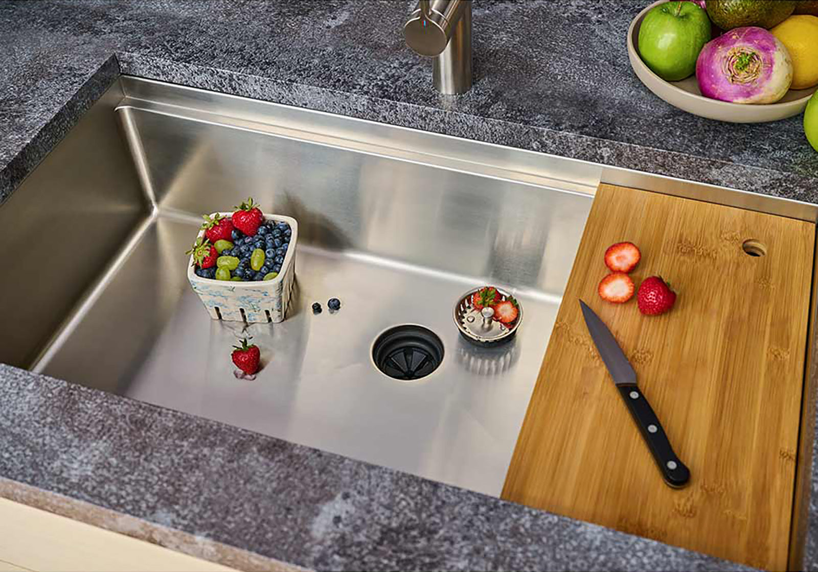 33-inch stainless steel workstation sink with bamboo cutting board and fresh produce. Single bowl undermount design for a functional and stylish kitchen.