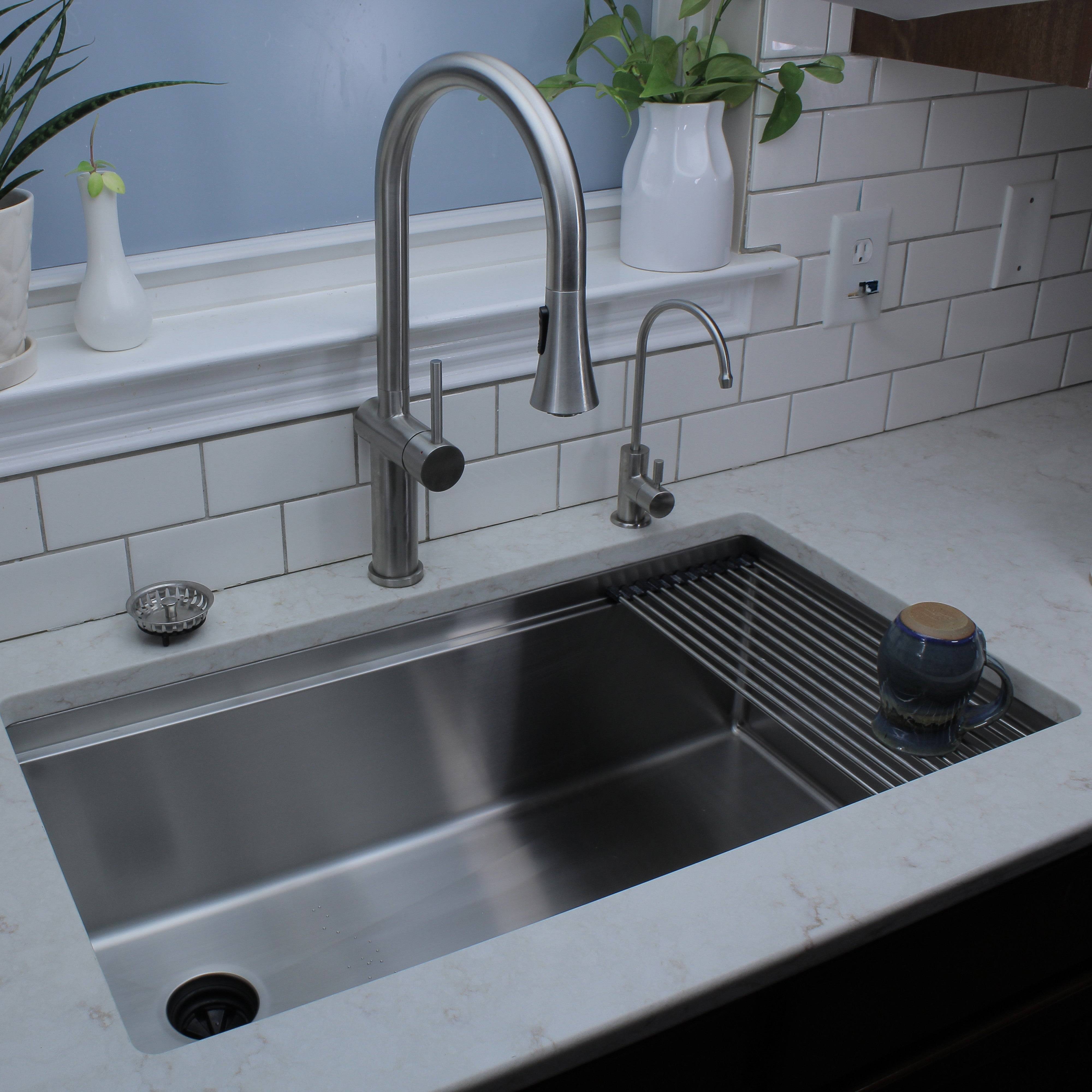 Bella stainless steel kitchen faucet installed over a large modern sink, complementing a sleek kitchen design with a tiled backsplash.