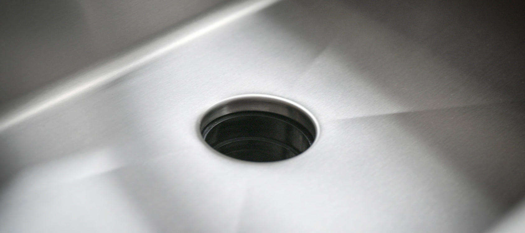 Close-up of a brushed 304 grade 16 gauge stainless steel sink basin with the Seamless Centerpiece Drain opening