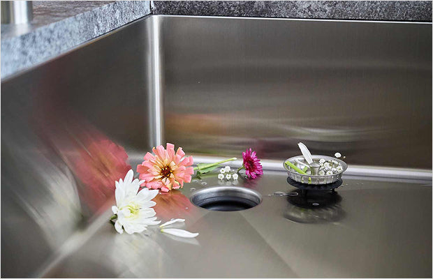 Offset drain placement leaves uninterrupted basin space in a workstation sink