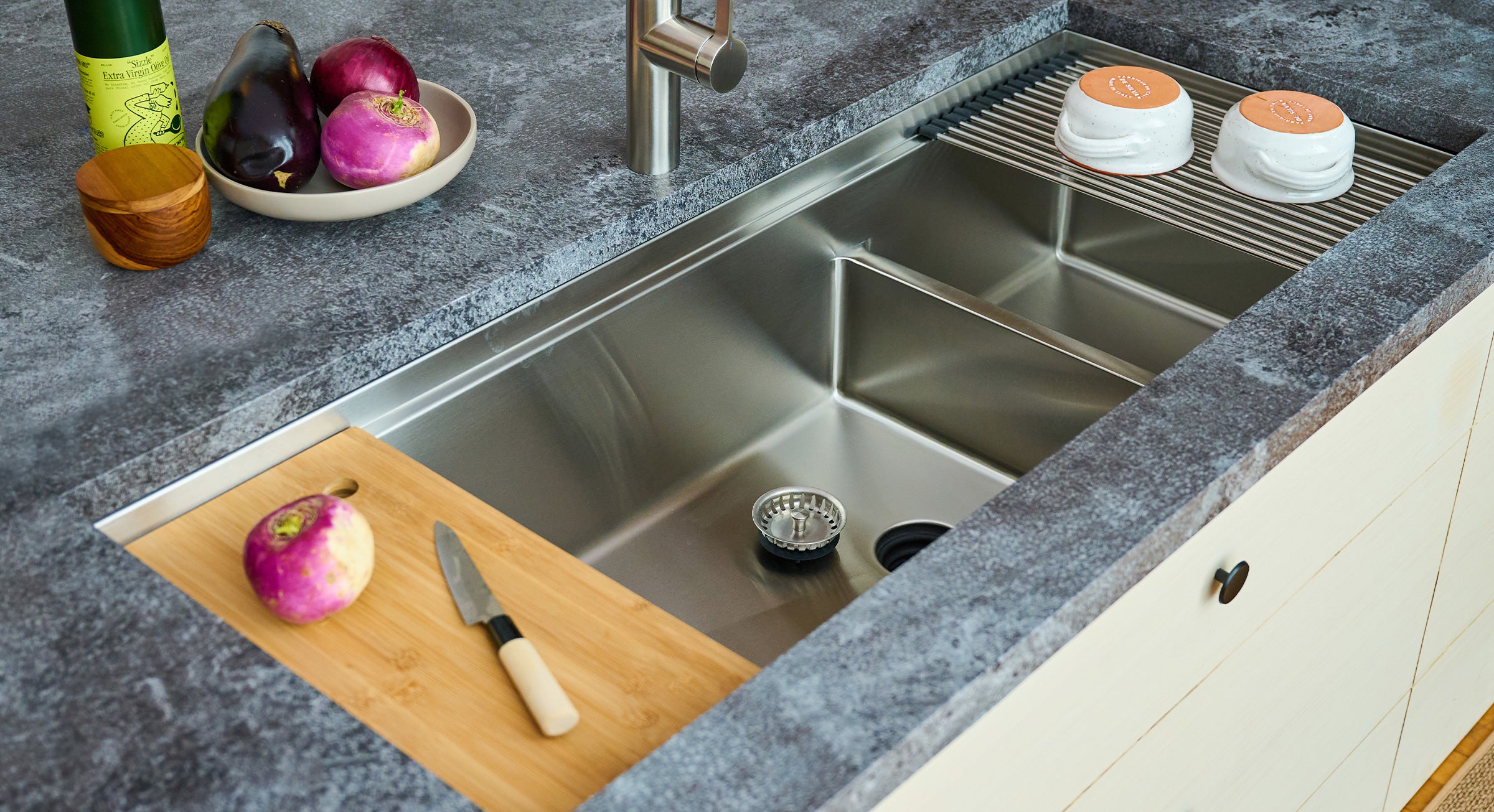 Create Good Sinks 50 inch stainless steel undermount double bowl workstation sink with undermount drain and workstation sink accessories for cutting vegetables and drying dishes over the sink. Shown with matching stainless steel faucet.