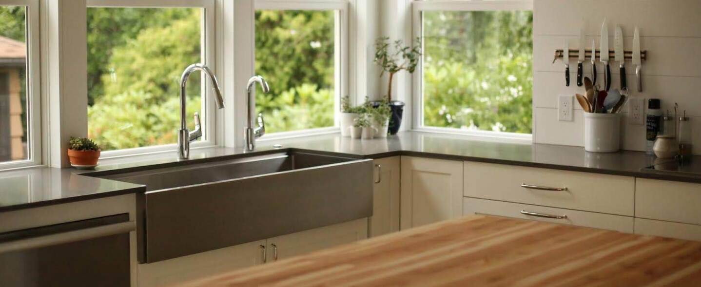 stainless steel farmhouse kitchen sink with apron front design and dual faucets and workstation ledge