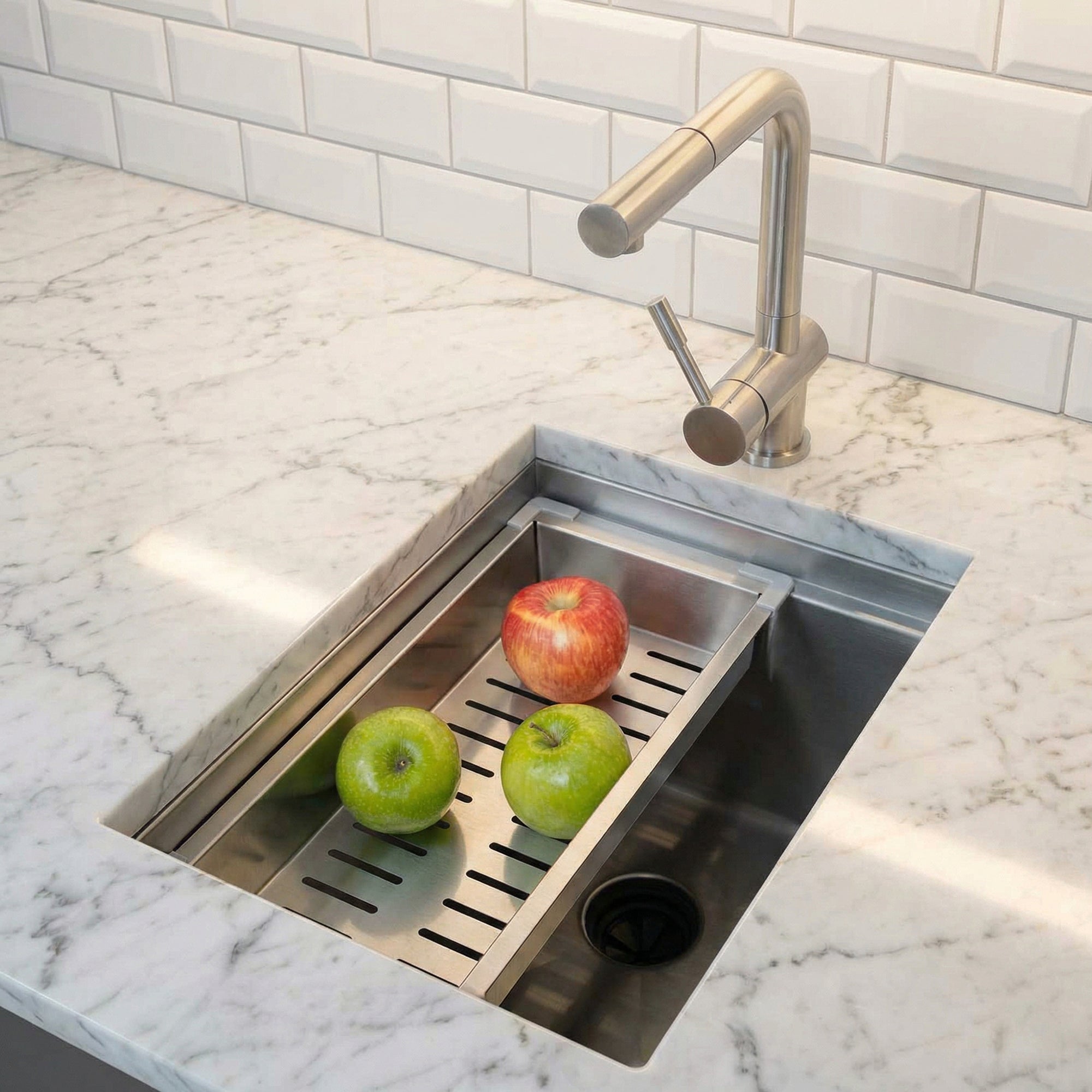15-inch stainless steel workstation bar sink with an integrated drying rack holding fresh apples. A functional addition to any kitchen or bar.