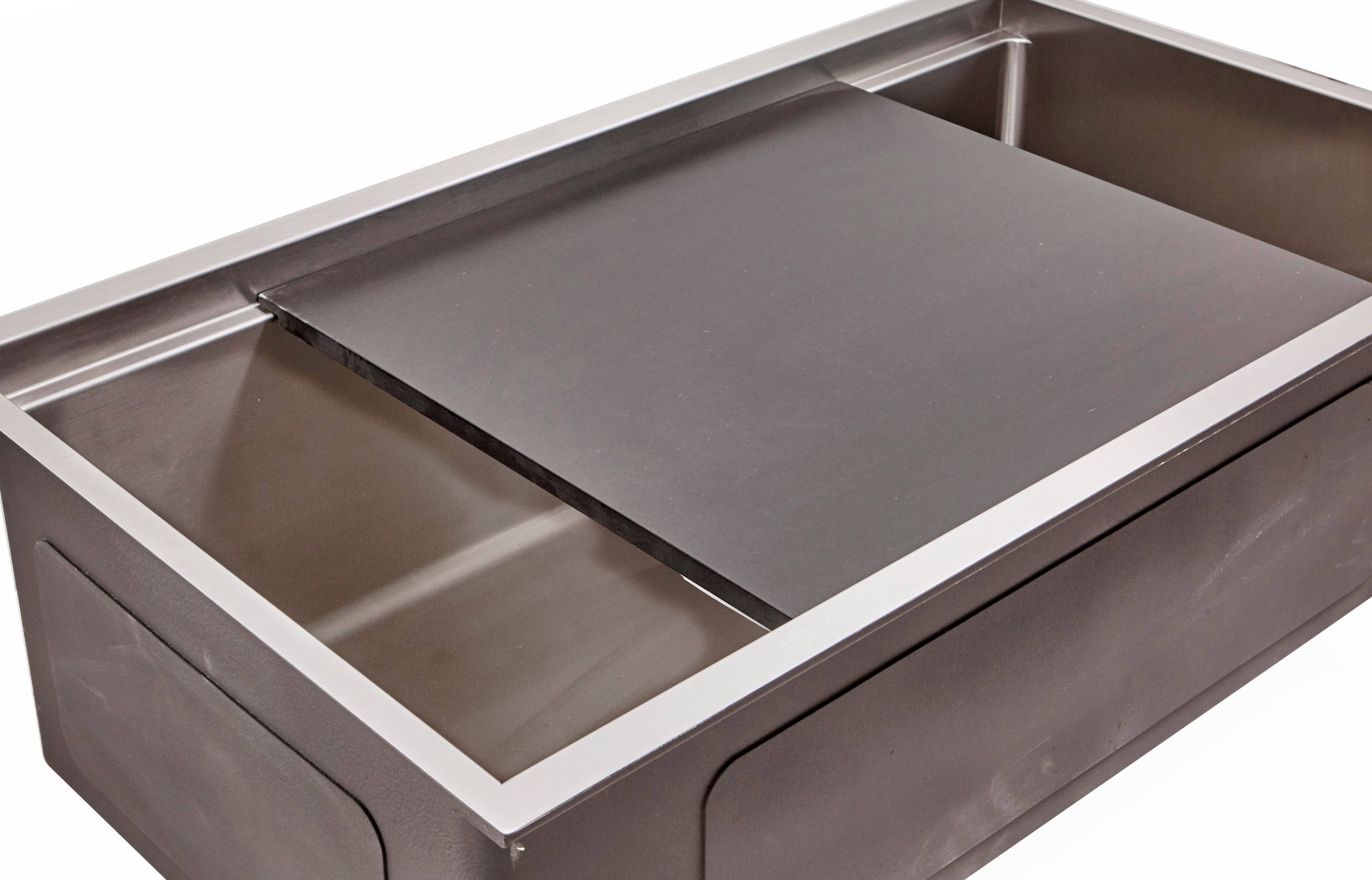 Black cutting board resting over a workstation sink, offering a sleek and durable surface for chopping and meal prep.
