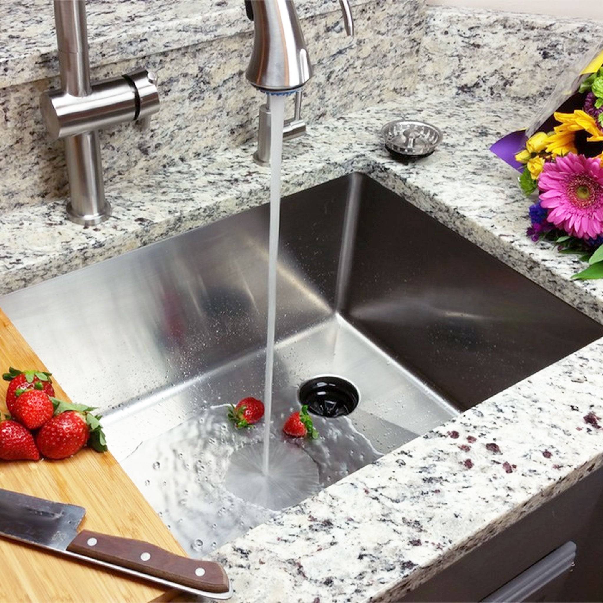 31-inch stainless steel undermount kitchen sink installed in a granite countertop, with running water and fresh produce for a stylish kitchen setup.