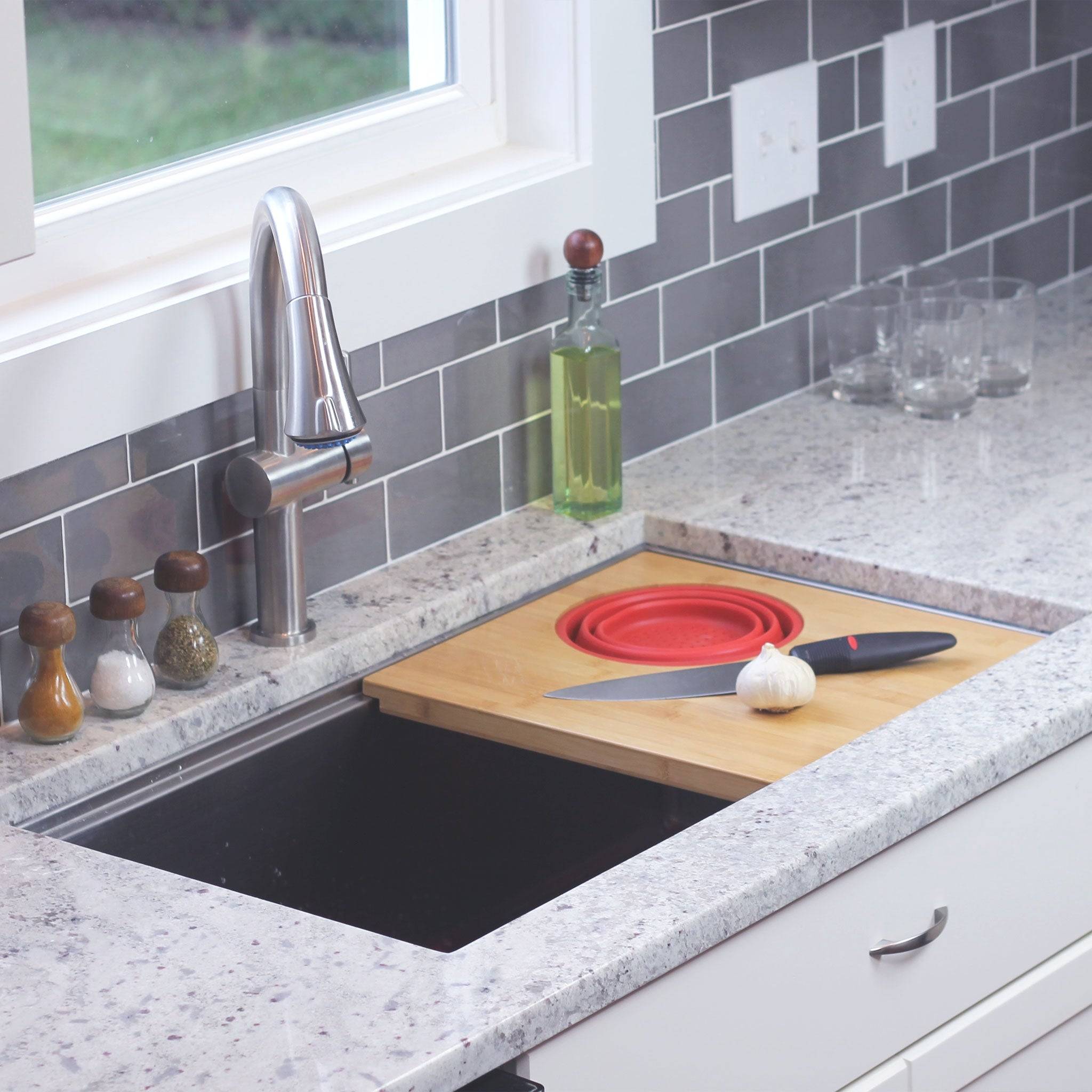 Seamless drain workstation sink with cutting board and silicone colander in Carrot Orange from Create Good Sinks