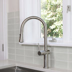 Bella stainless steel kitchen sink faucet with a high-arc design and brushed finish, installed in a modern kitchen with a tiled backsplash.