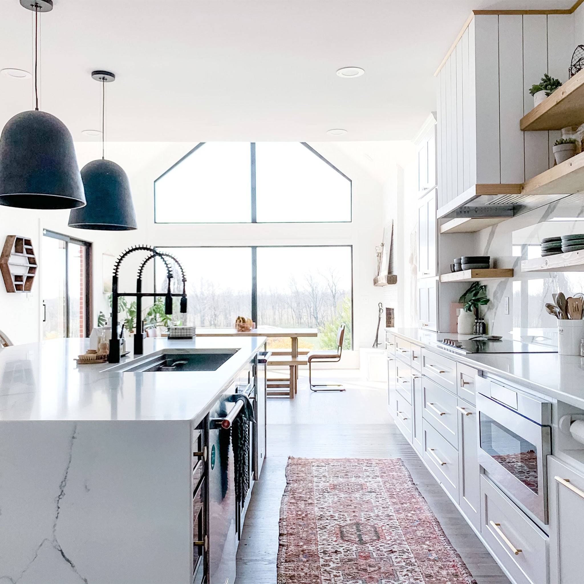 Bright and modern kitchen with a 46-inch workstation sink, featuring a sleek design, dual black faucets, and a spacious island layout.